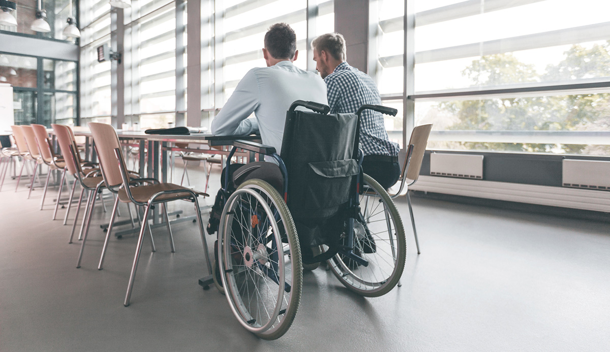 Disabled businessman working with his colleague in an office